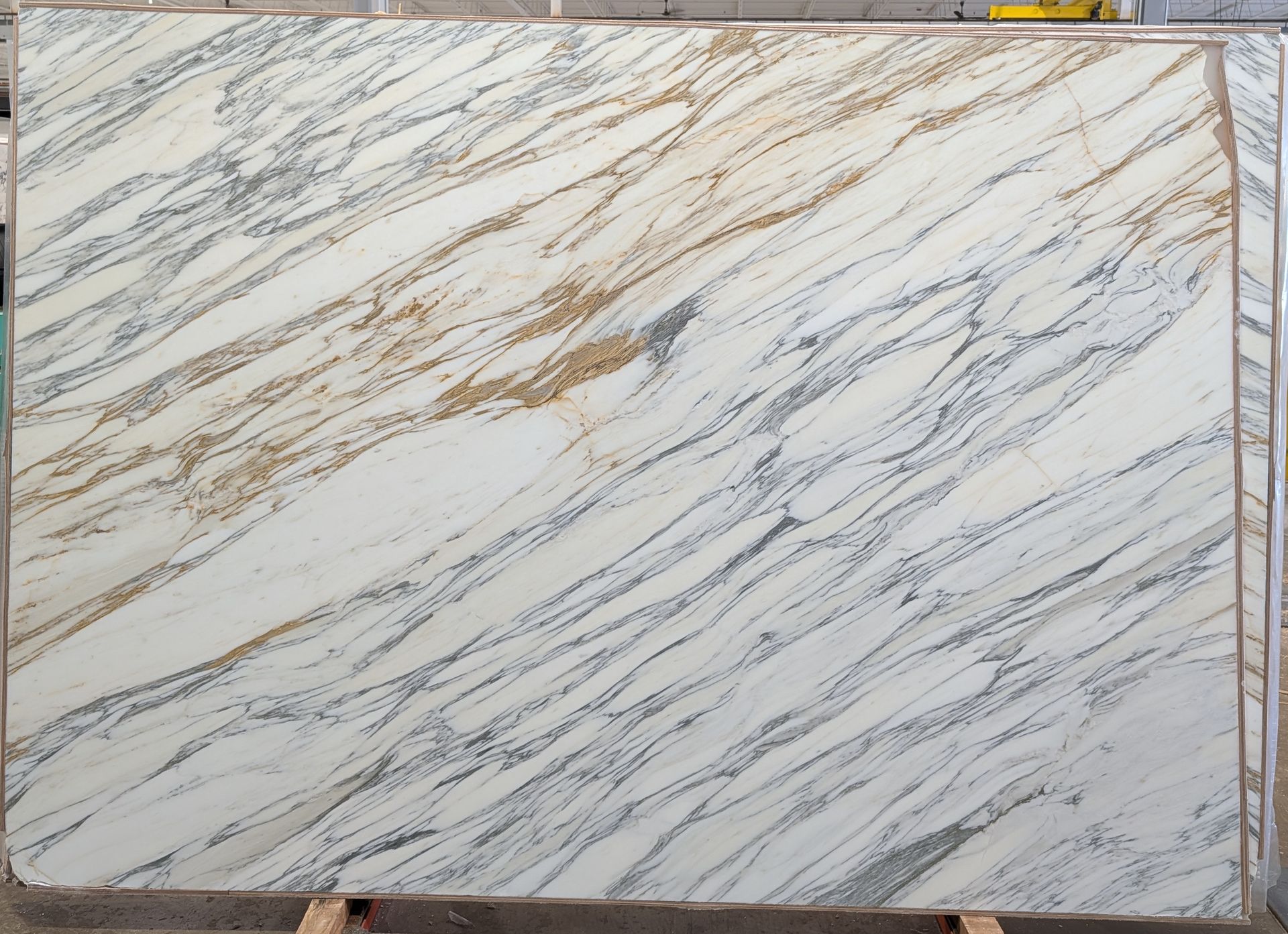 White marble-patterned slab with gray and gold veining in a rectangular frame.