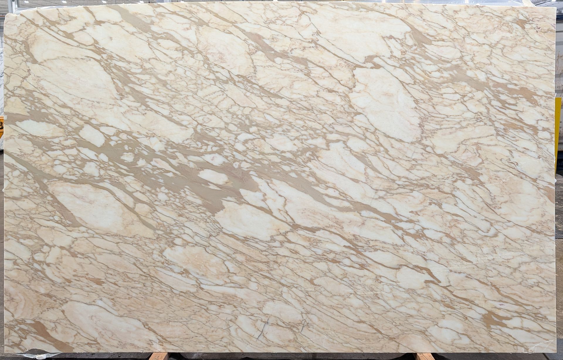 Beige marble slab with white and brown veining texture.
