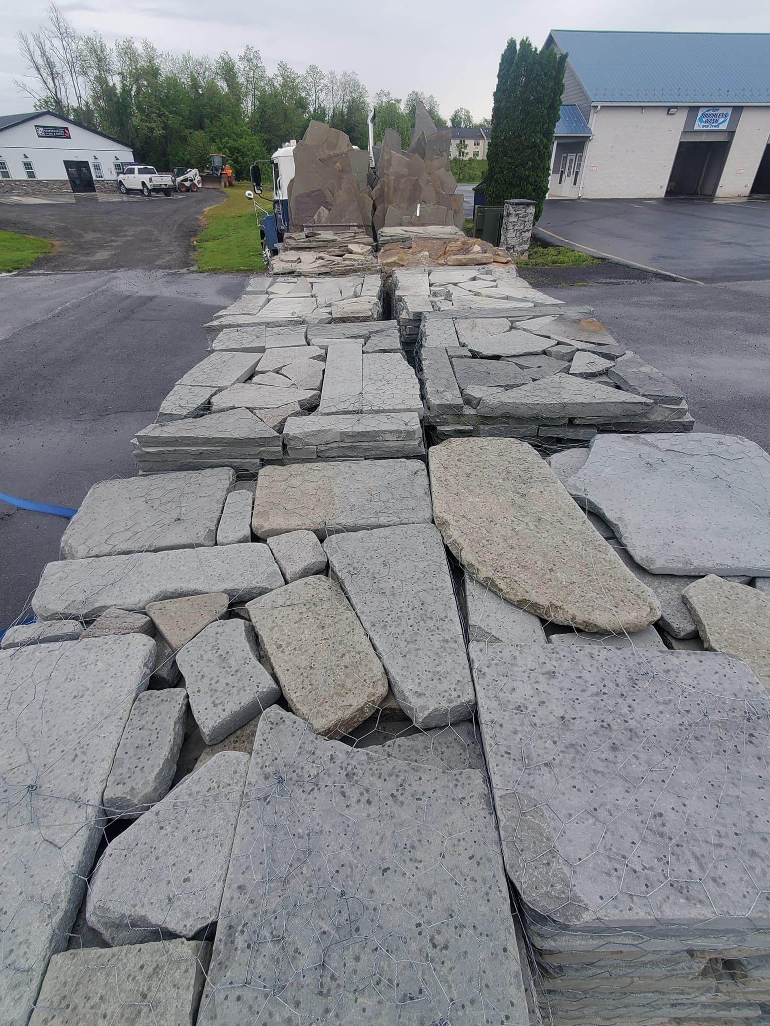 A pile of rocks is sitting on the ground in a parking lot.