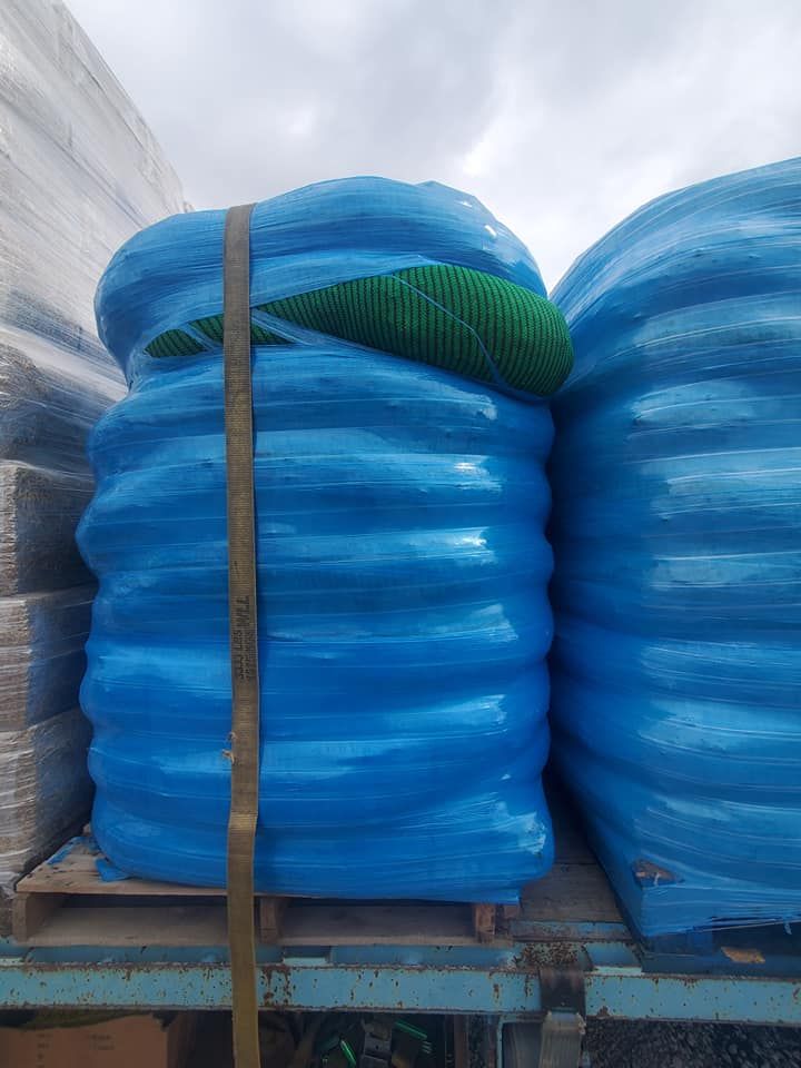 A bunch of blue bags are stacked on top of each other on a truck.