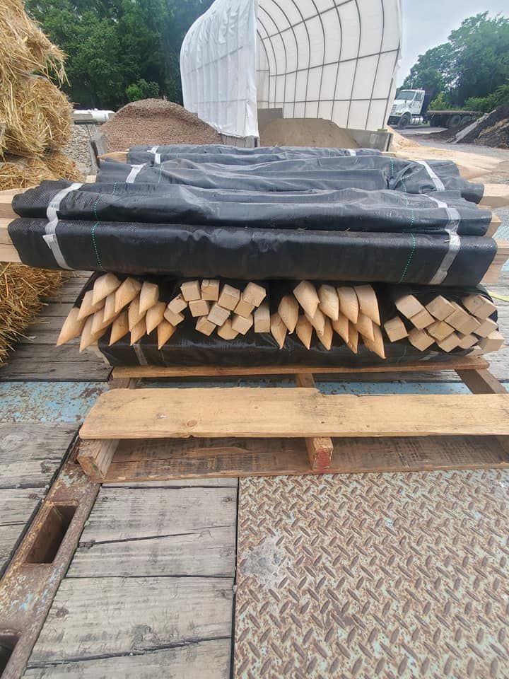 A pile of wooden poles sitting on top of a wooden pallet.