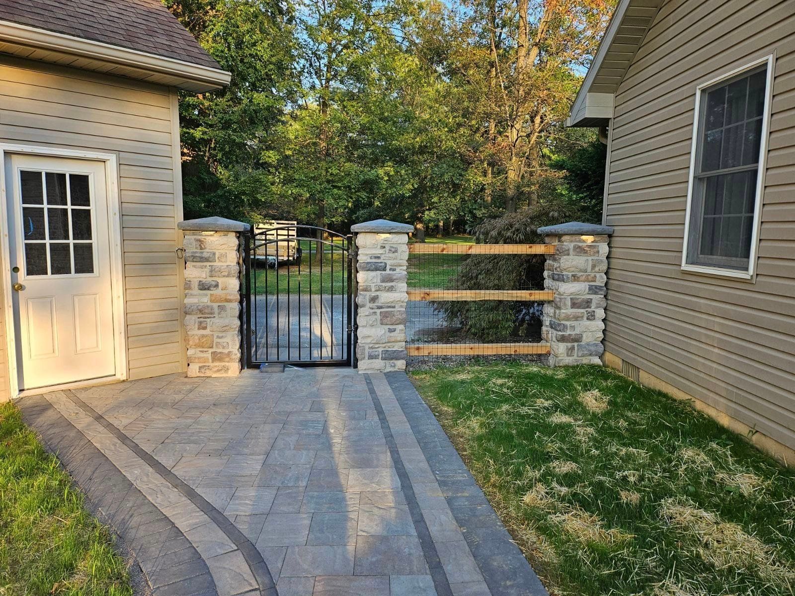 A house with a fence and a gate in front of it.