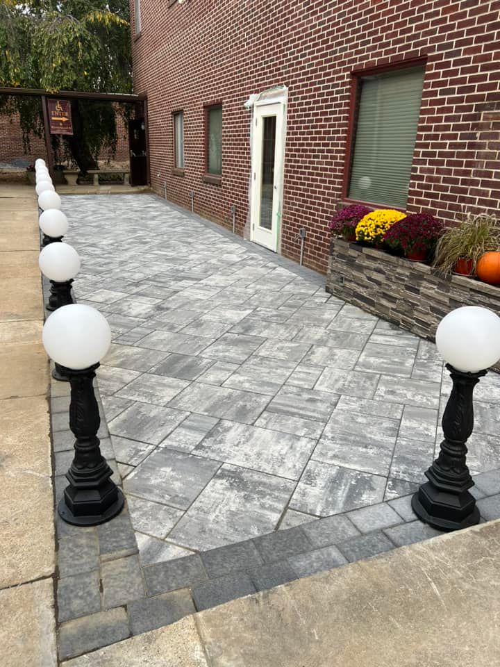 A brick building with a patio and a row of lights in front of it.