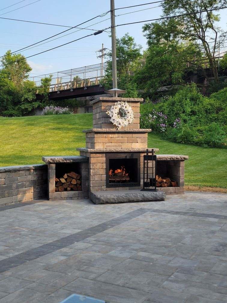A patio with a fireplace and a wreath on top of it.