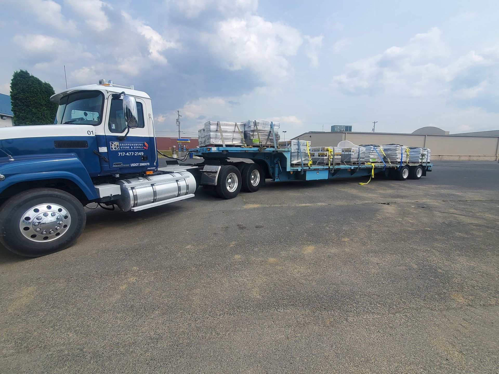 A blue and white semi truck is parked in a parking lot