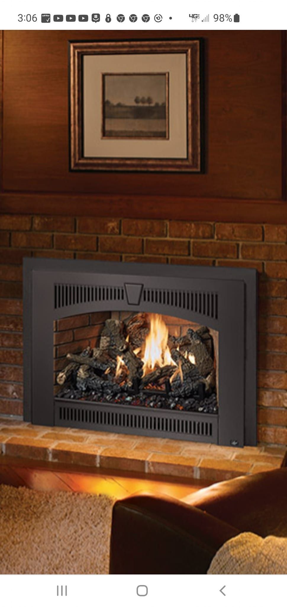 A living room with a fireplace and a picture on the wall.
