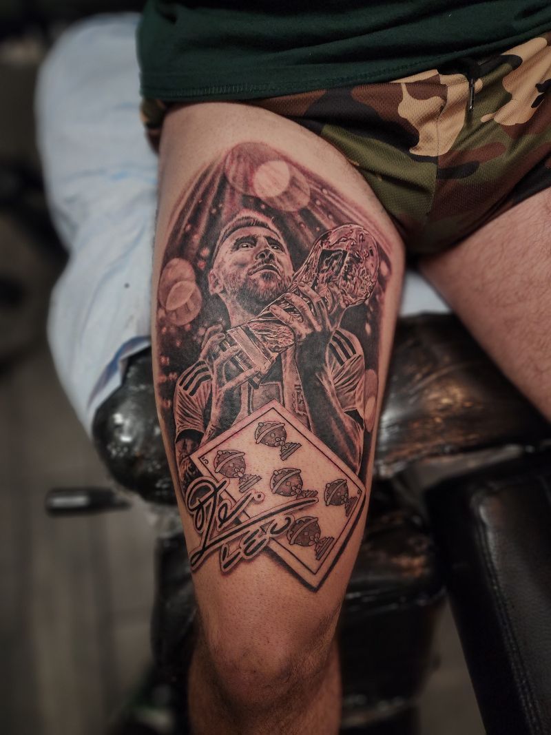 A man has a tattoo of a man holding a playing card on his leg