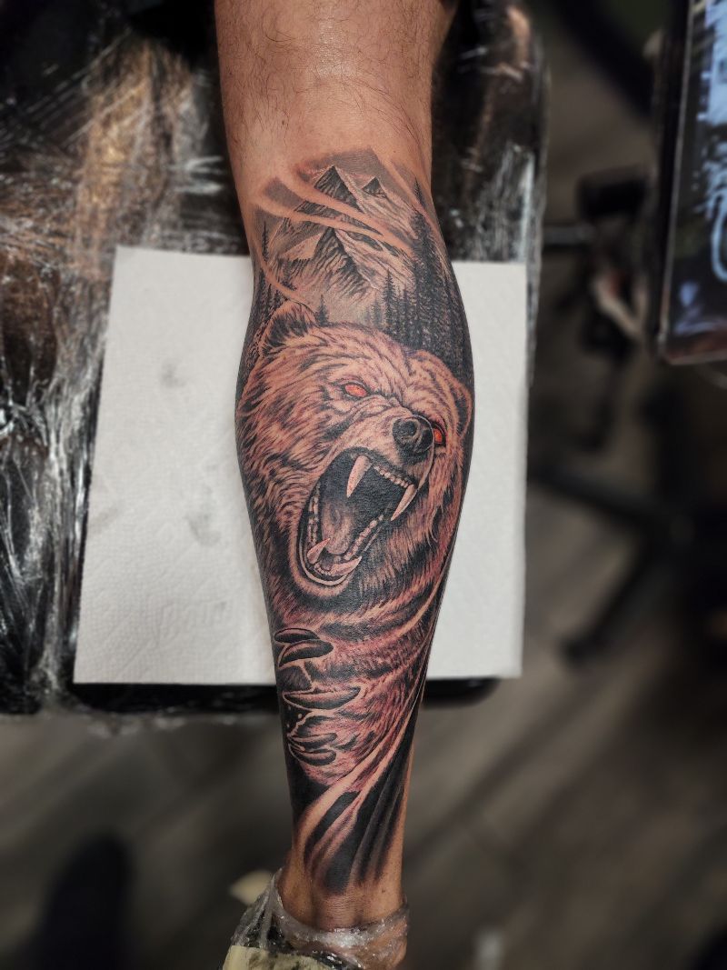 A person has a tattoo of a bear on their leg.