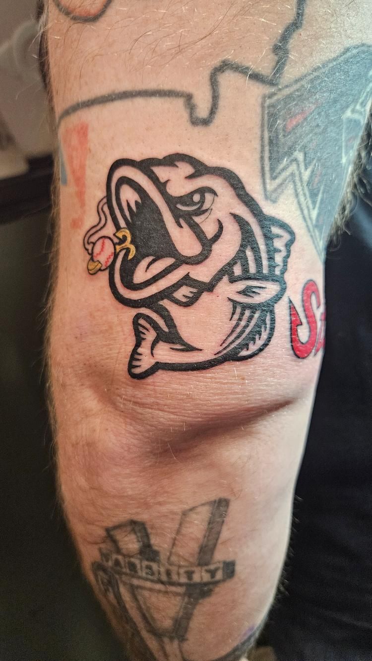 A man has a tattoo of a fish on his elbow.