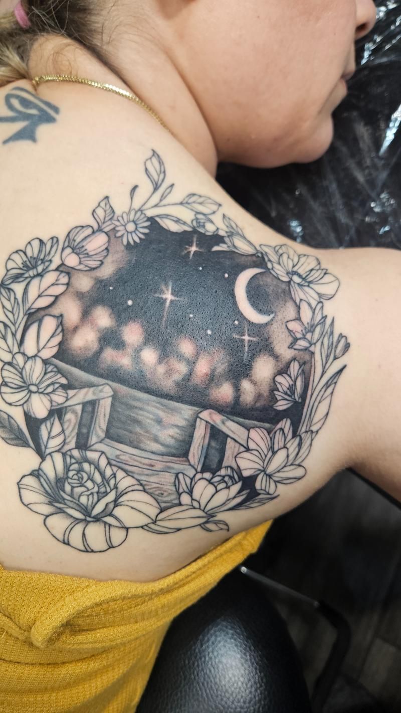 A woman has a tattoo of a crocodile skull with butterflies on her back.