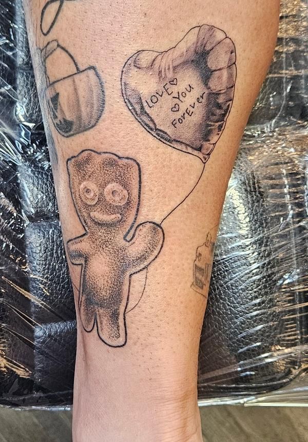 A person has a tattoo of a teddy bear holding a heart shaped balloon.