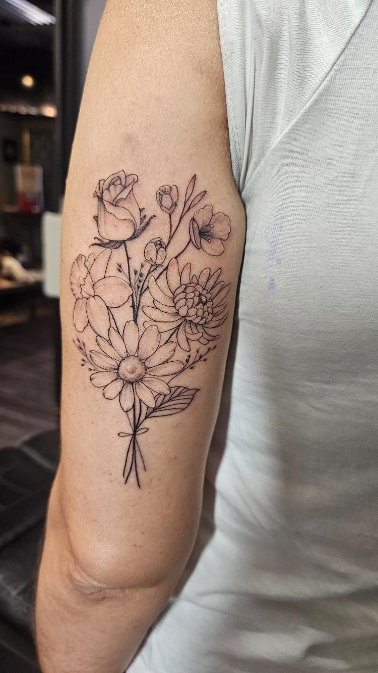A woman has a tattoo of flowers on her arm.
