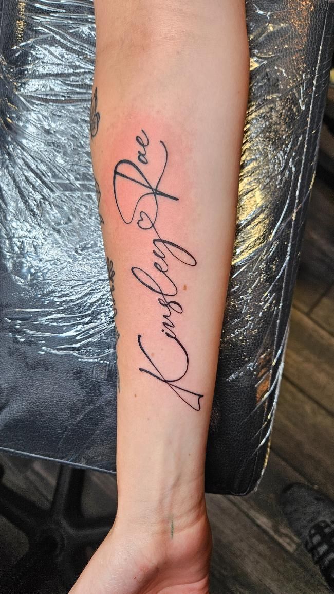A person has a tattoo on their forearm that says kimberly and joe