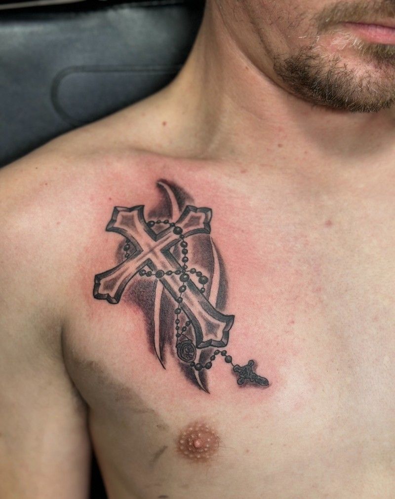 A man has a cross tattoo on his chest