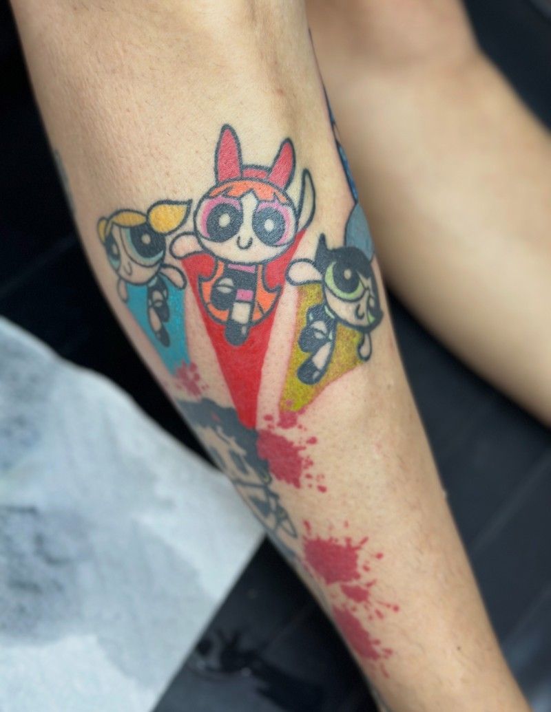 A person has a tattoo of the powerpuff girls on their leg