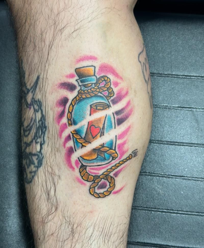 A man has a tattoo of a bottle with a heart in it on his leg.