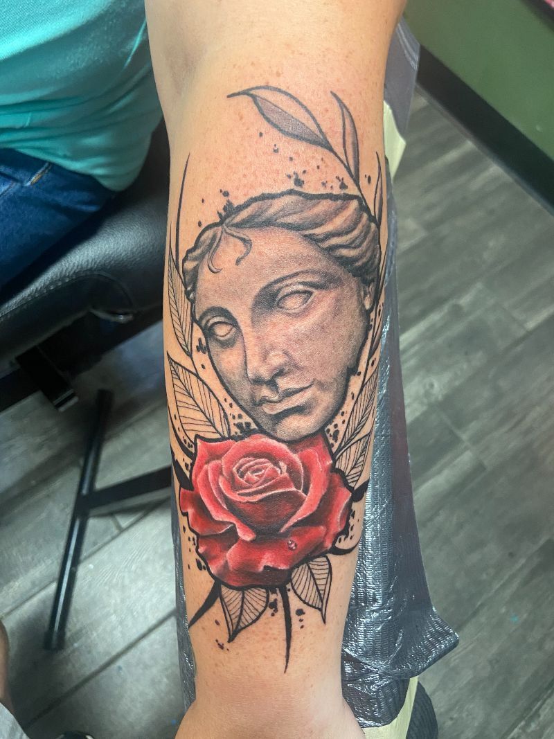 A tattoo of a woman 's face with a red rose