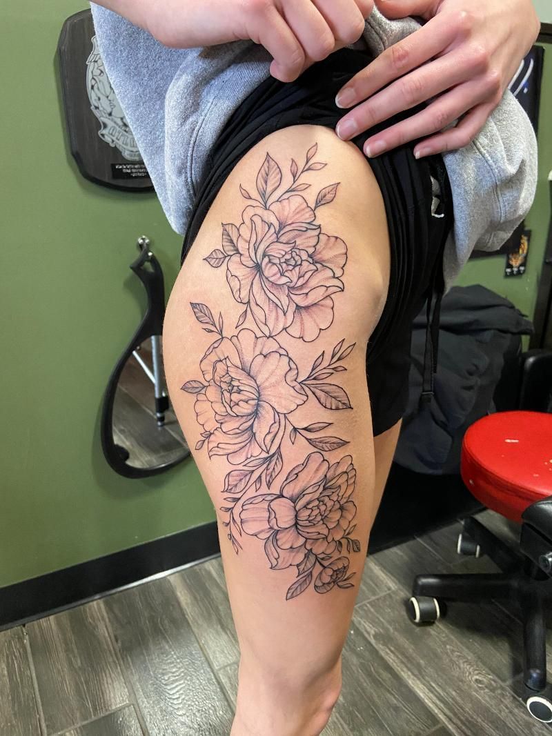 A woman has a tattoo of flowers on her leg.