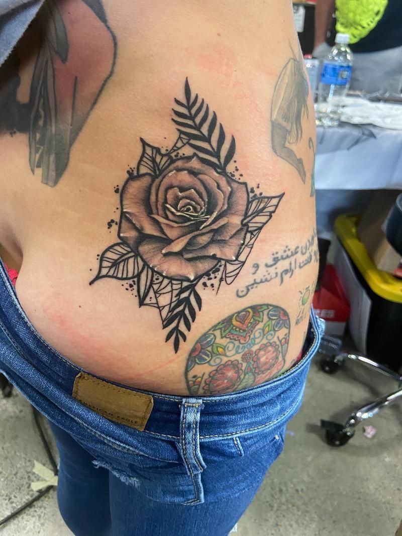 A woman has a tattoo of a rose on her side