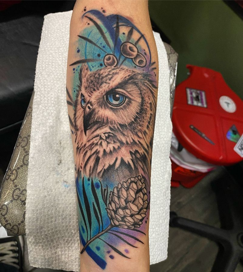 A person has a tattoo of an owl on their arm