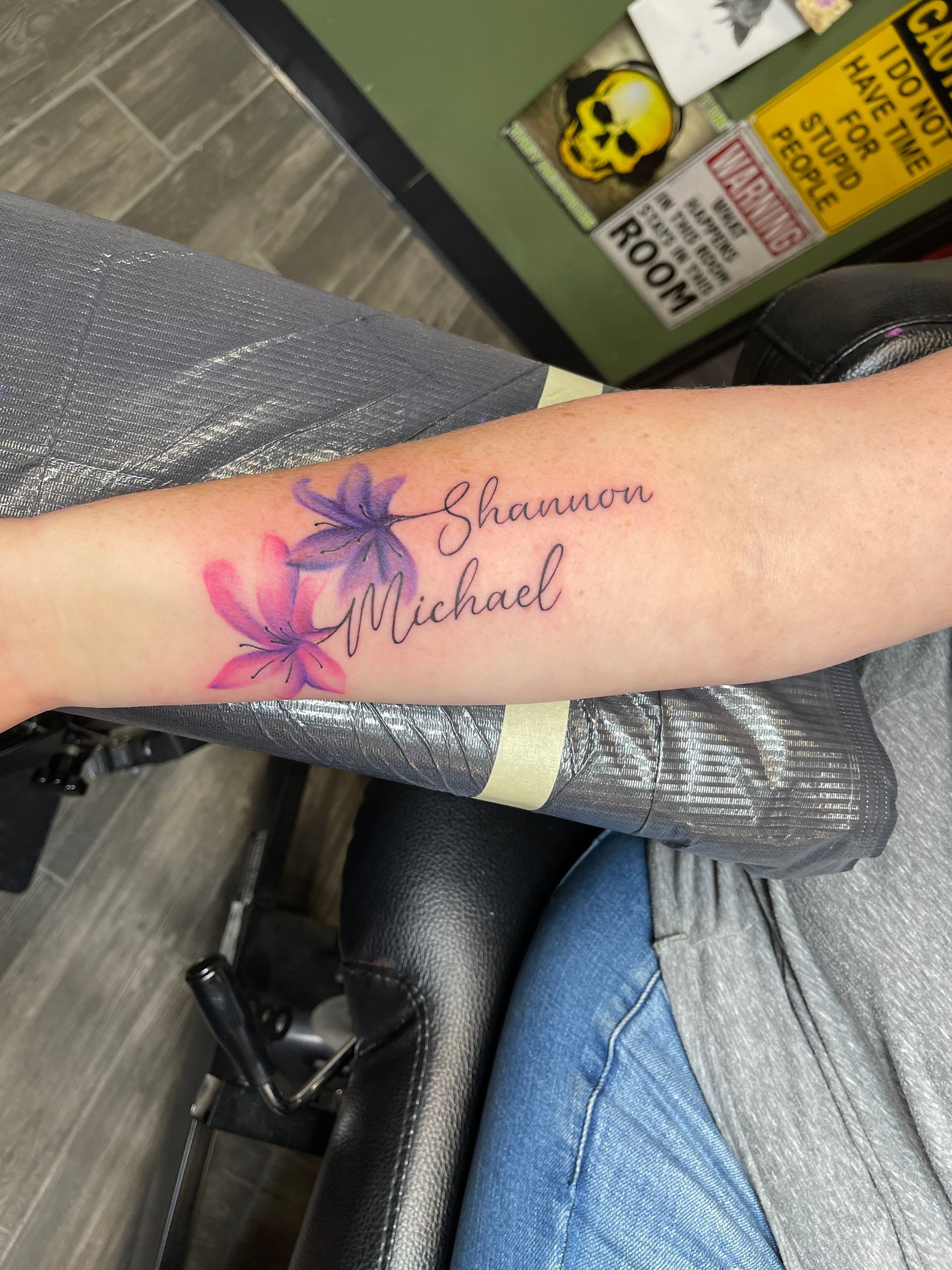 A person has a tattoo on their arm that says shannon michael