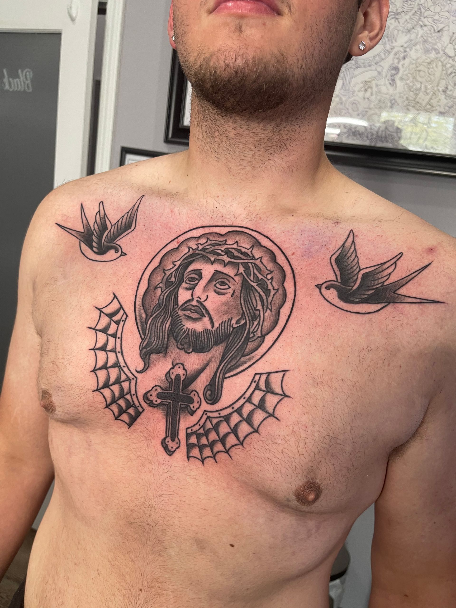 A man has a tattoo of jesus on his chest