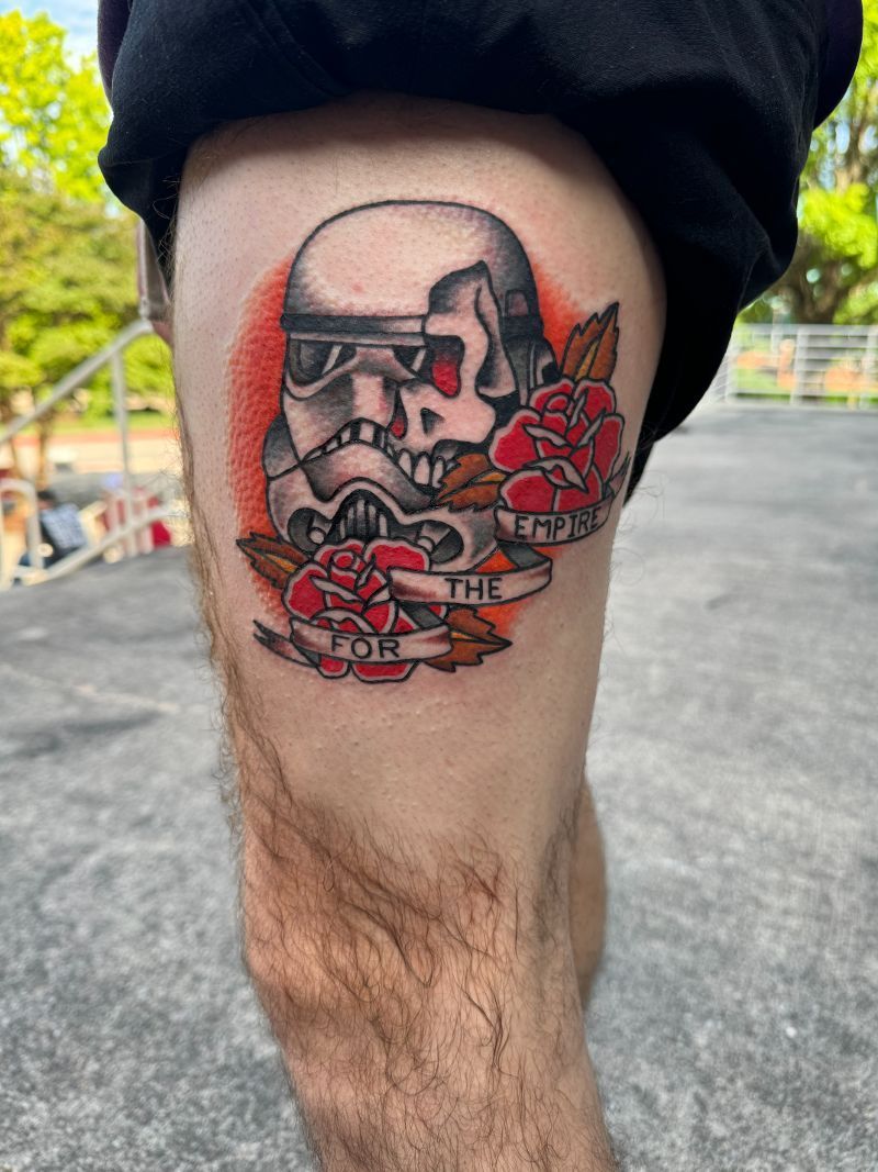 A person has a tattoo of a storm trooper skull and roses on their leg.