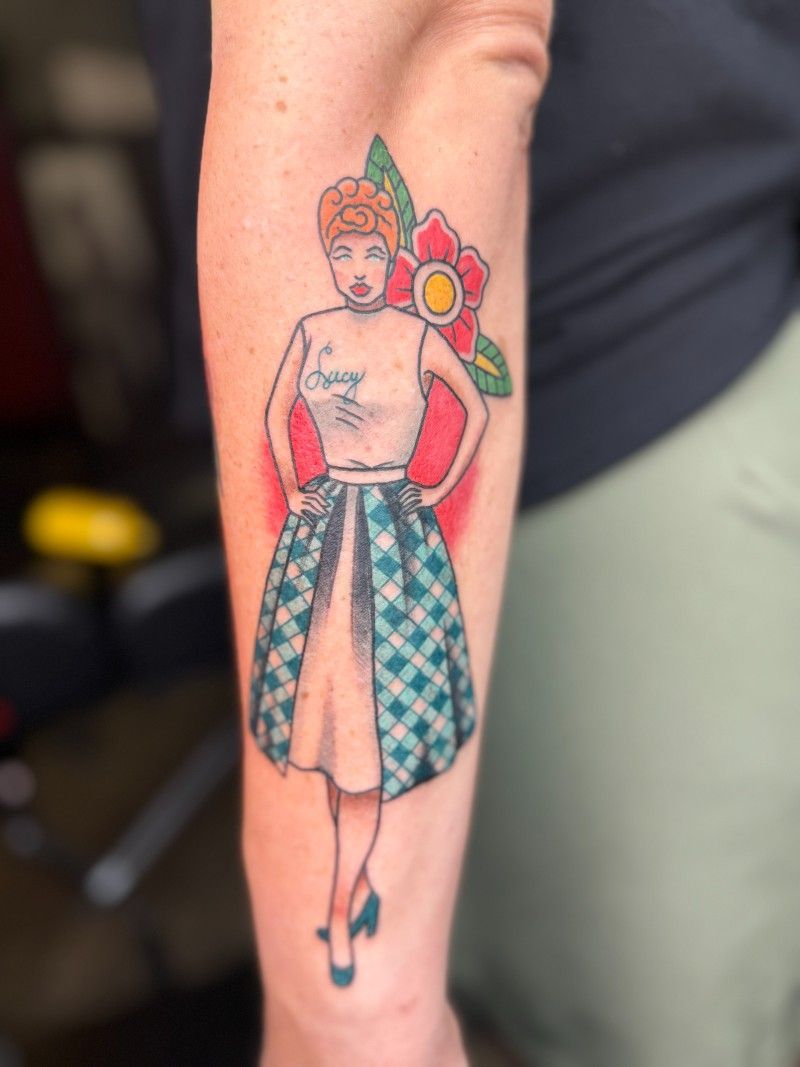 A woman has a tattoo of a woman in a plaid dress