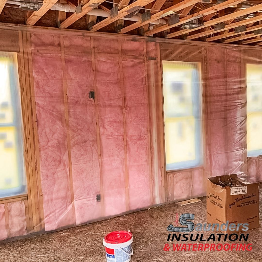 A room with pink insulation on the walls and windows.
