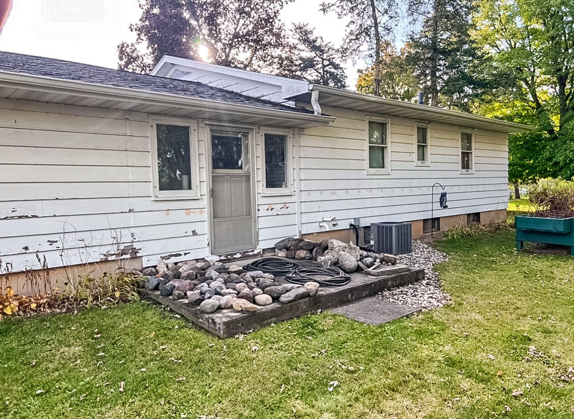 A white house with a fire pit in the backyard.