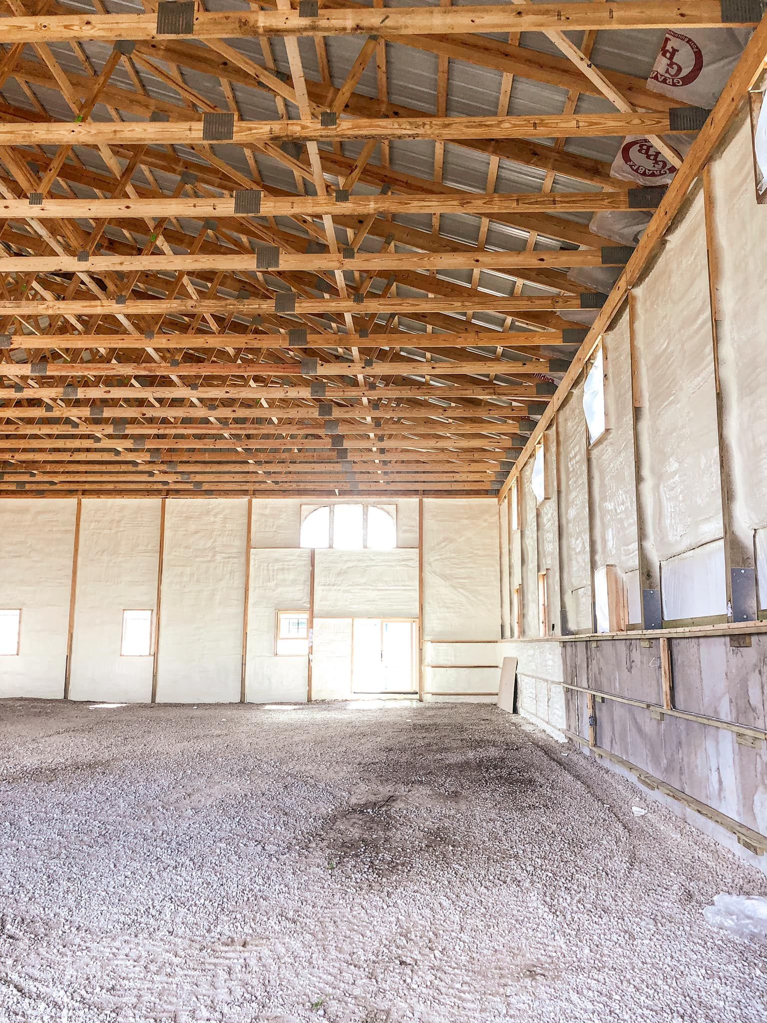 A large empty building with a wooden roof and a lot of windows.