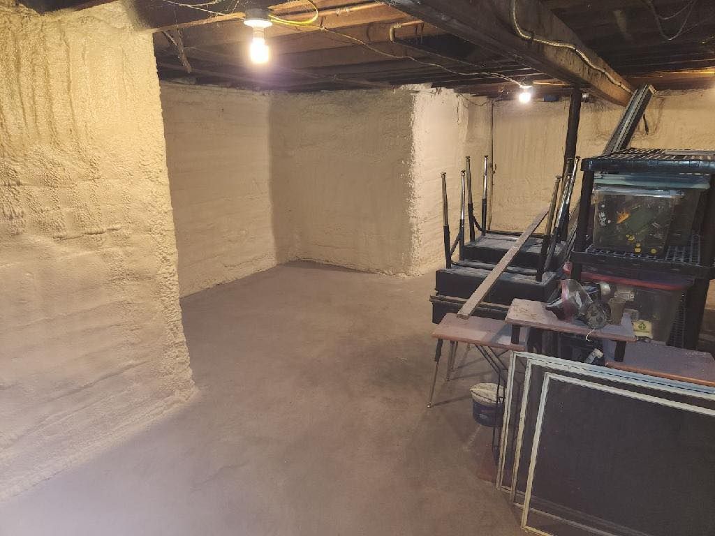 An empty basement with a table and chairs in it.