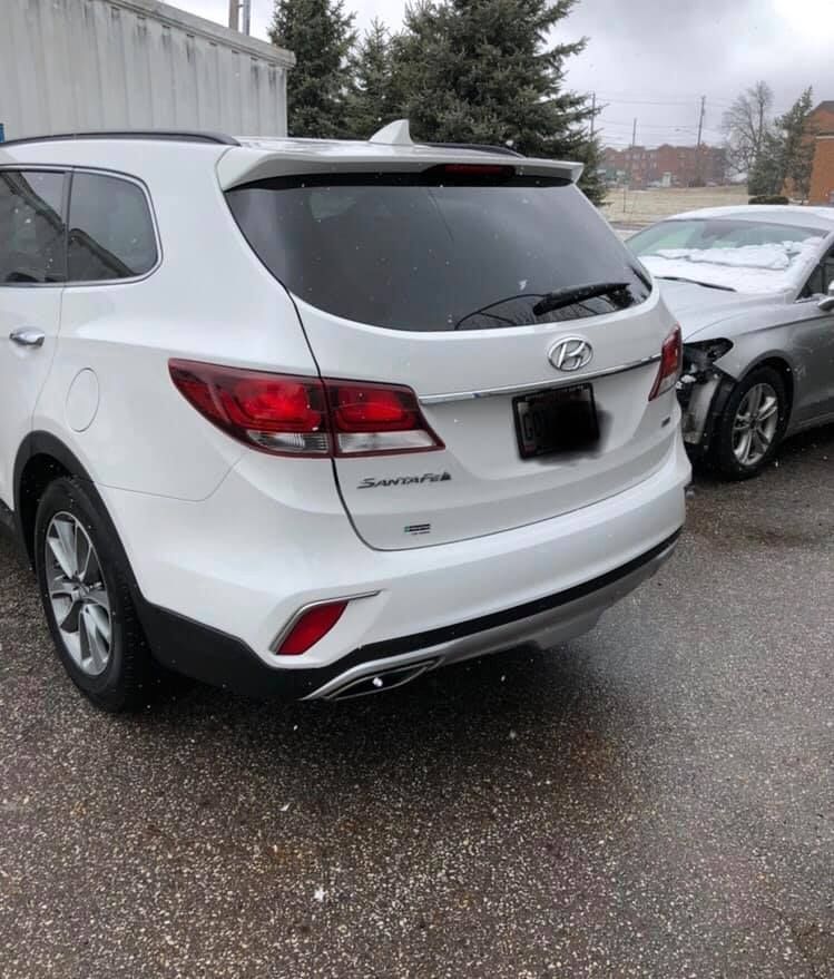 A white suv is parked next to a silver car in a parking lot.