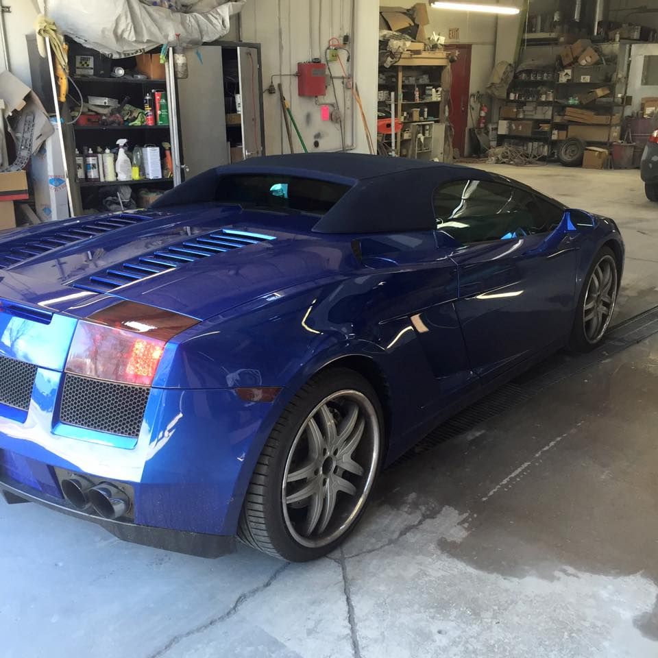 A blue sports car is parked in a garage