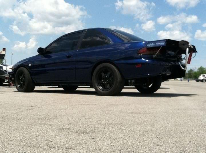 A blue car is parked on the side of the road