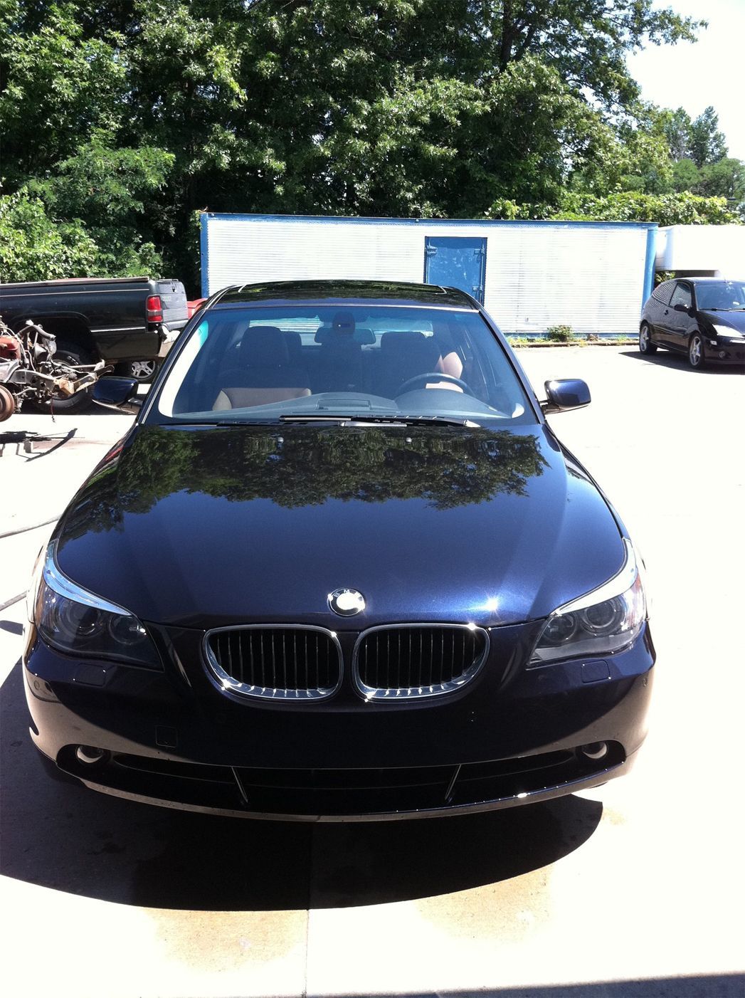 A black bmw is parked in a parking lot