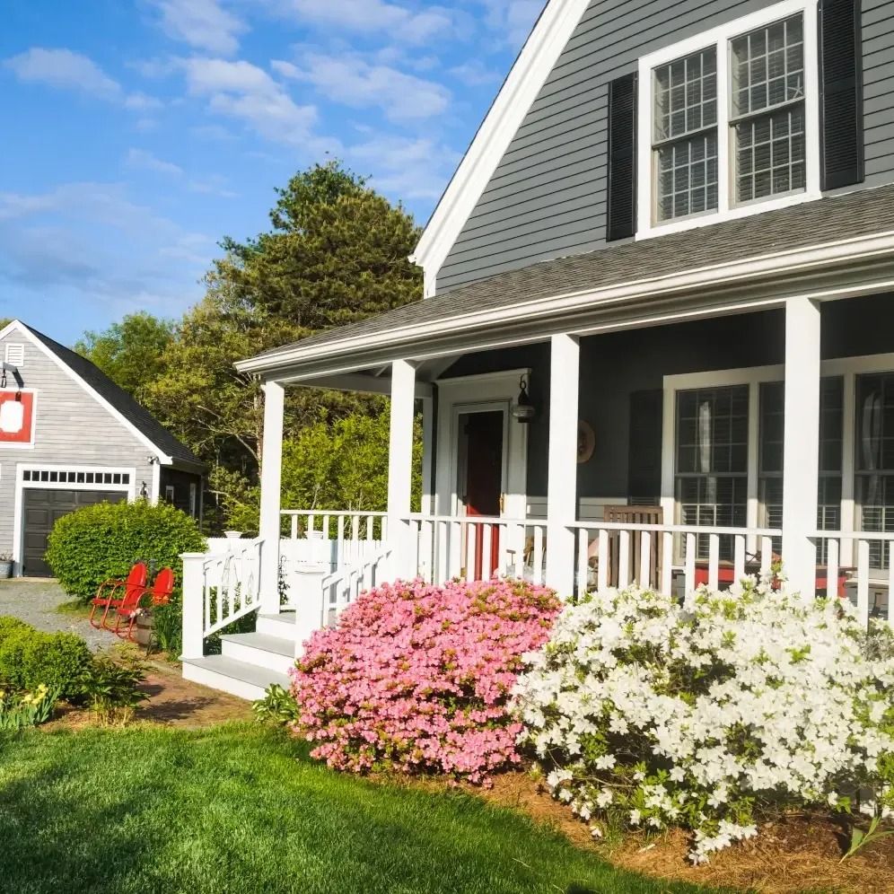 A house with a porch and flowers in front of it