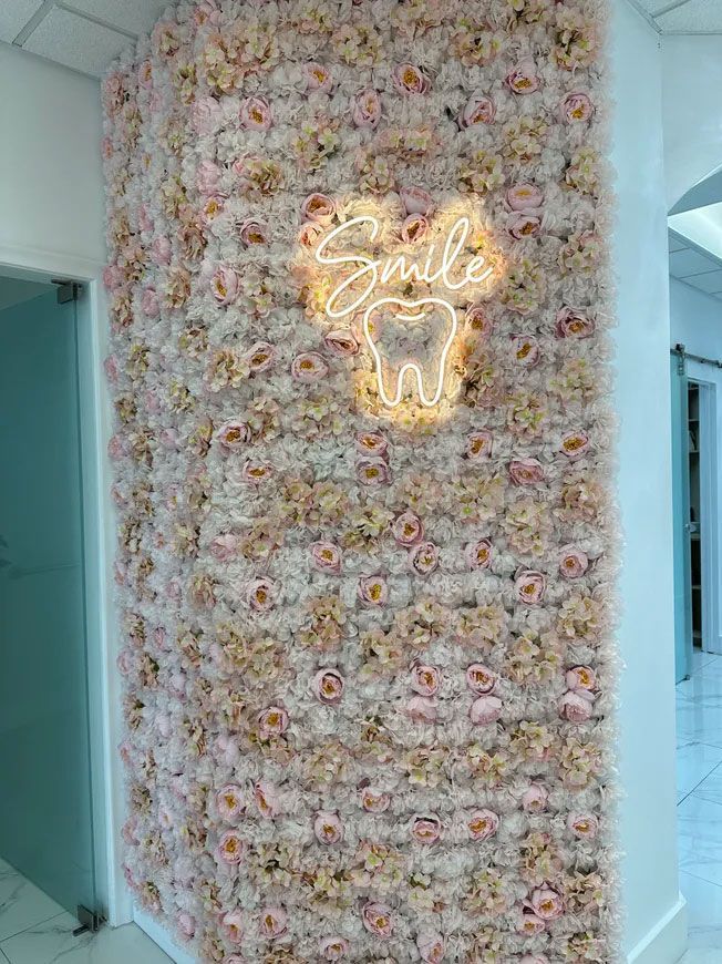 Wall decorated with pink and white flowers; a neon 