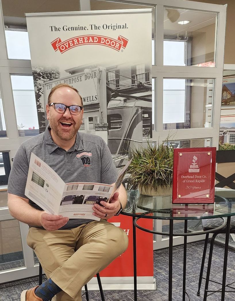 A man is sitting at a table reading a magazine.