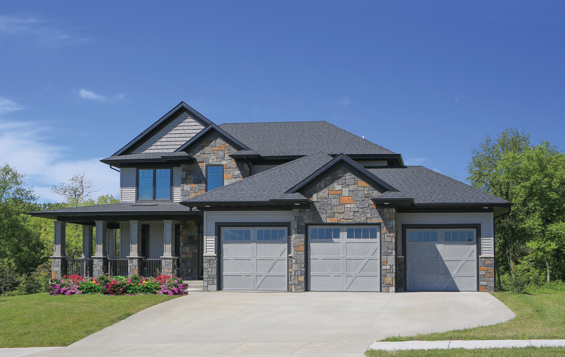 A large house with three garage doors and a driveway