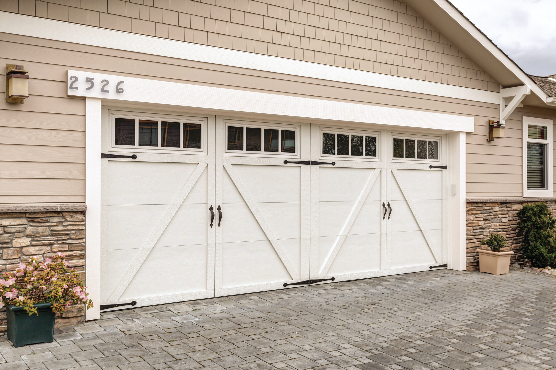 A large white garage door is sitting in front of a house.