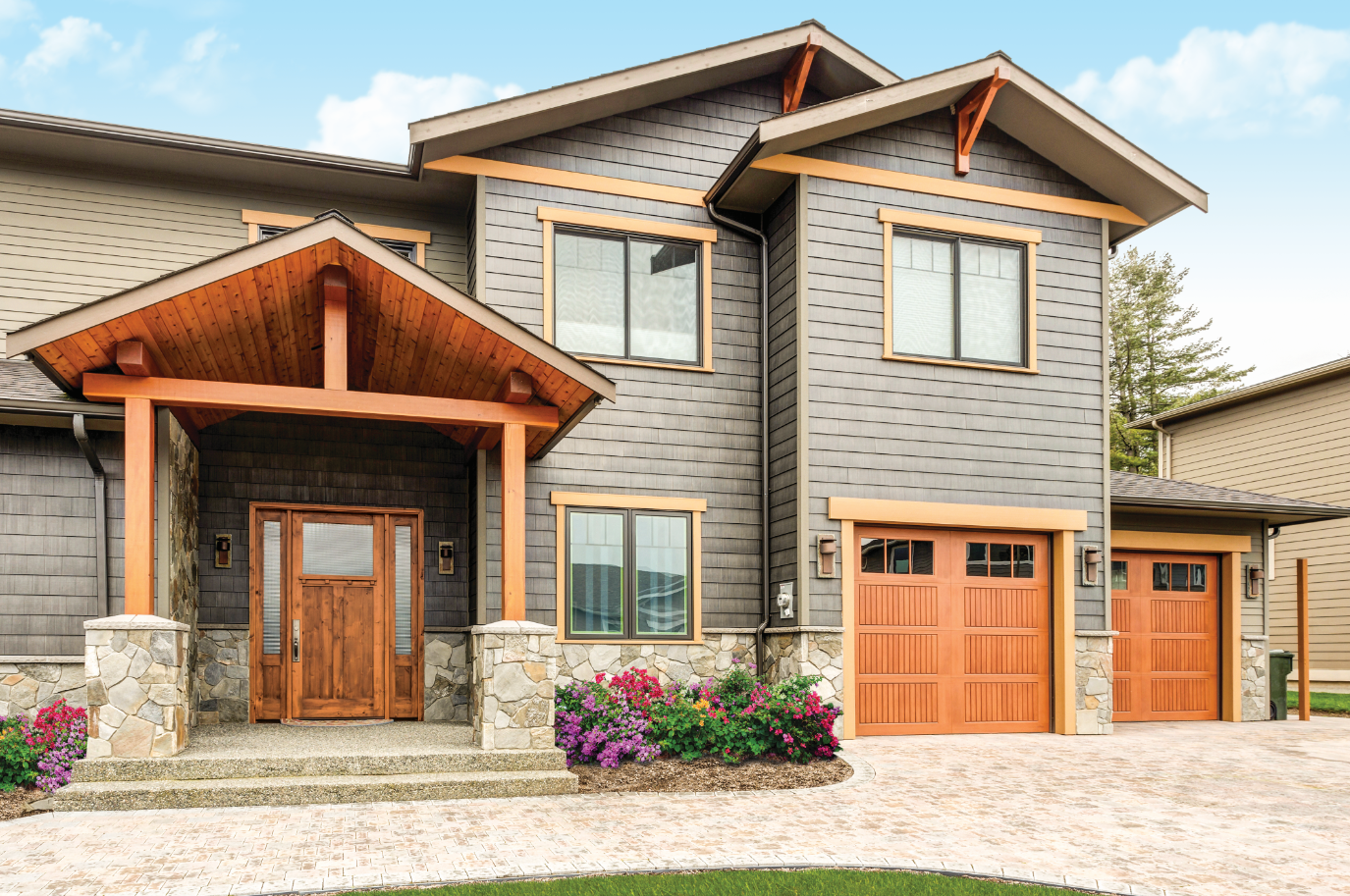 A large house with two garage doors and a porch.