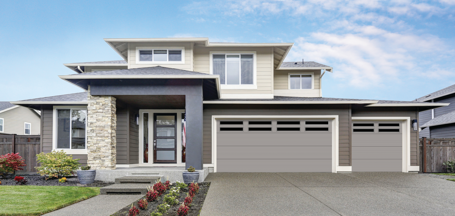 A large house with two garage doors and a driveway.