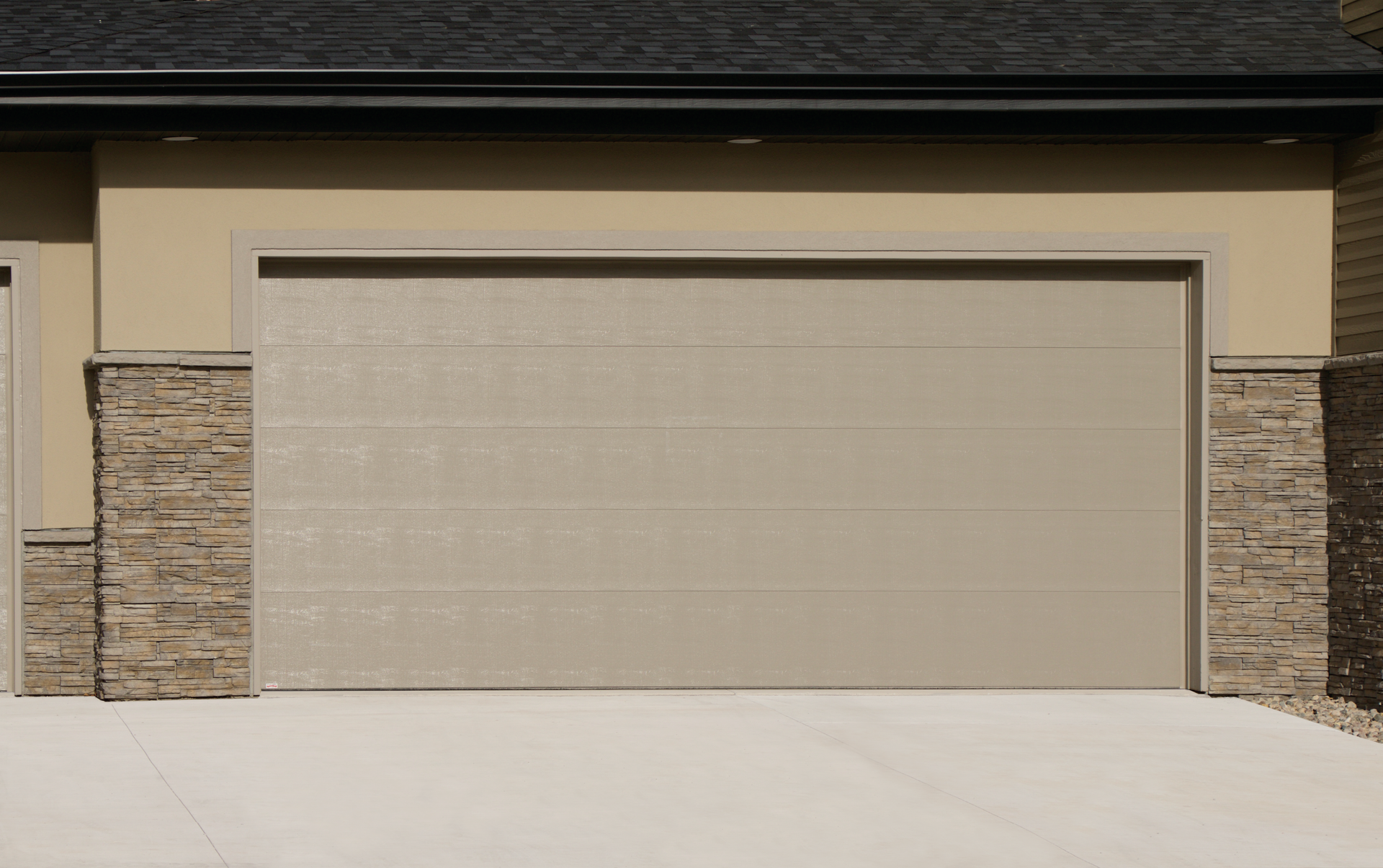 There is a garage door on the side of a house.