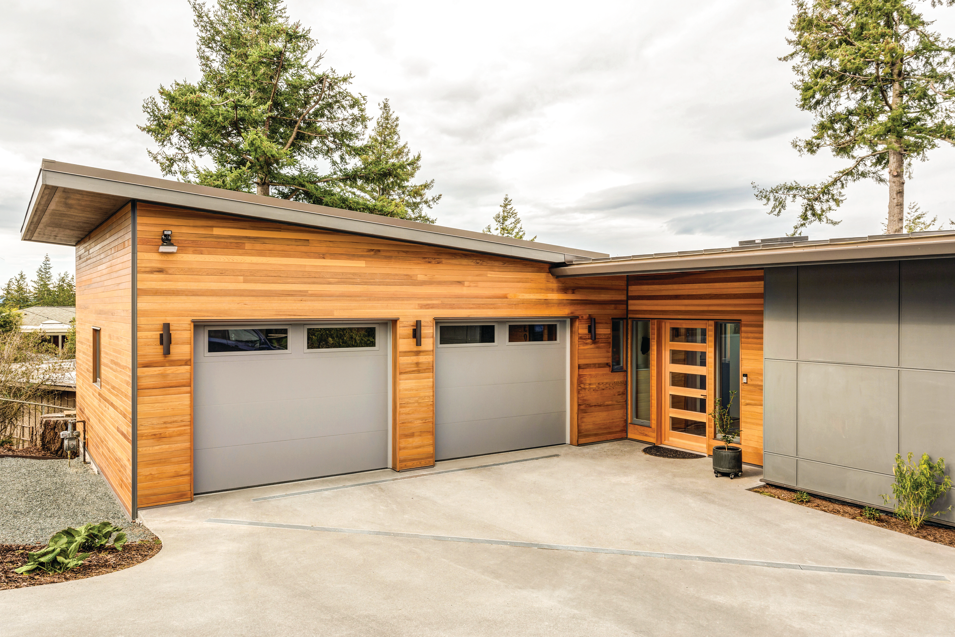 A house with a garage and a driveway in front of it.