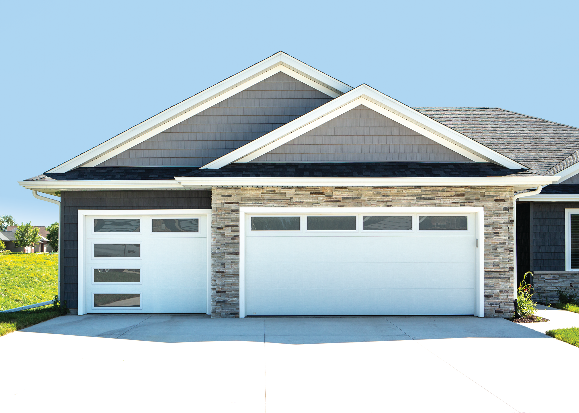 A house with a white garage door and a gray siding.