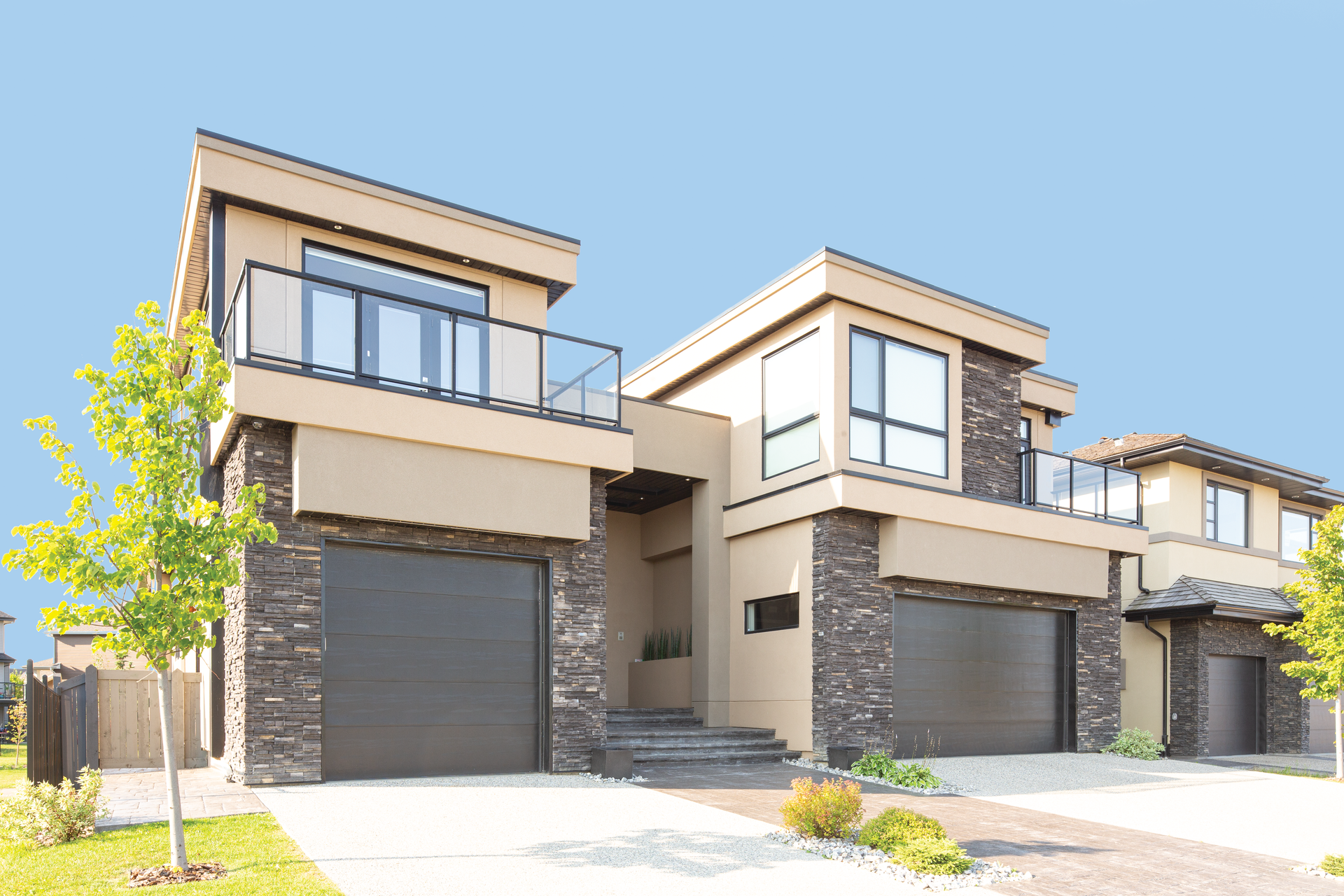 A large house with two garages and a balcony.