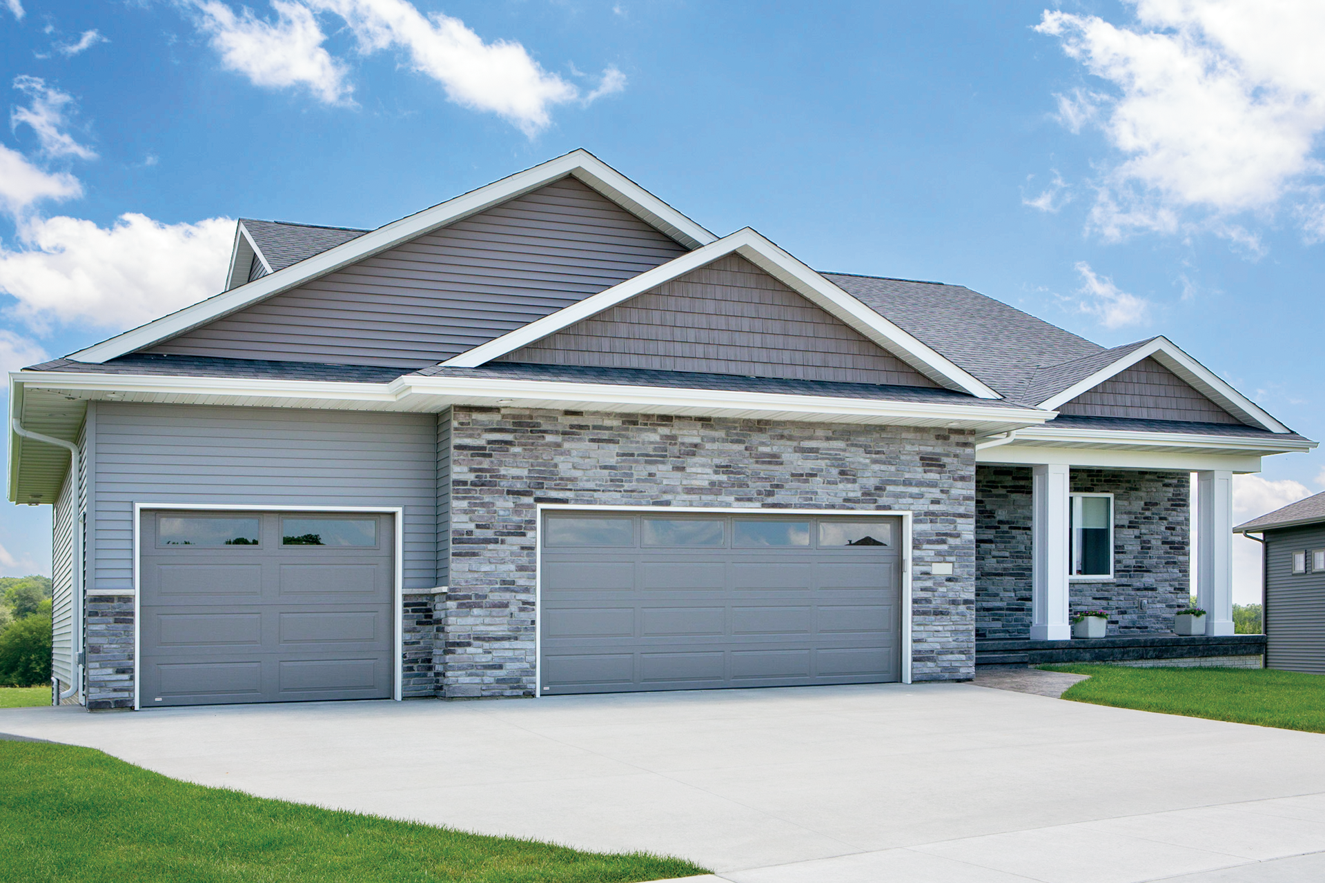 A large house with two garage doors and a driveway.