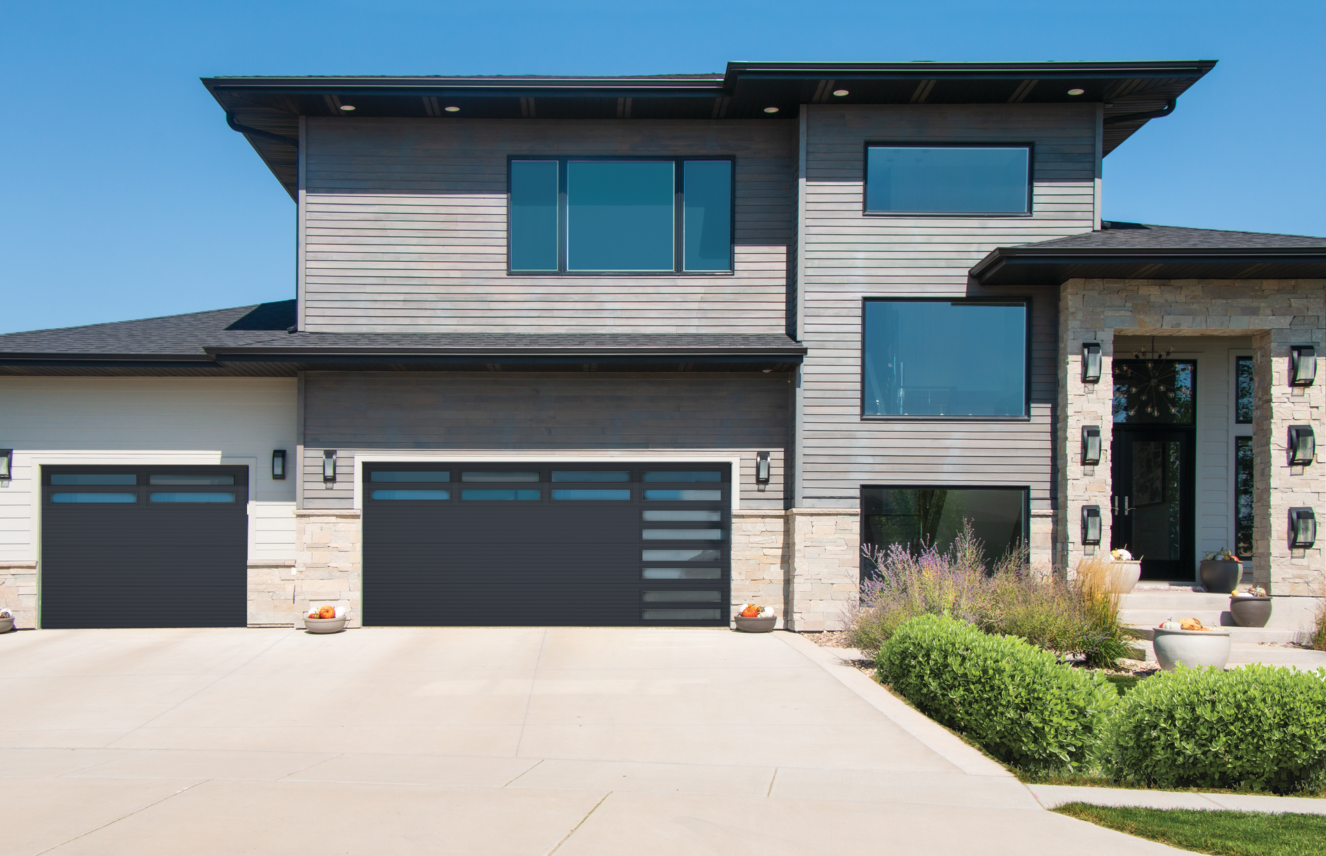 A large house with two garage doors and a lot of windows.