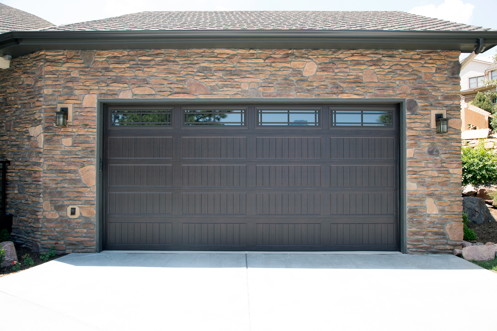 A large garage door is sitting in front of a stone building.